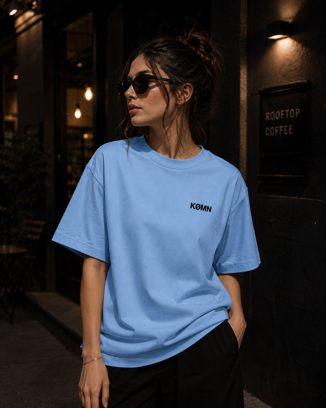 Female model in KØMN light blue oversized t-shirt front view, heavyweight cotton casual streetwear tee