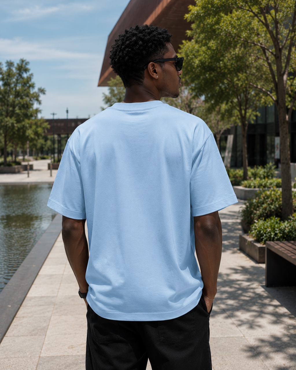 Back view of men wearing KØMN sky blue oversized t-shirt, heavyweight 100% cotton crewneck tee