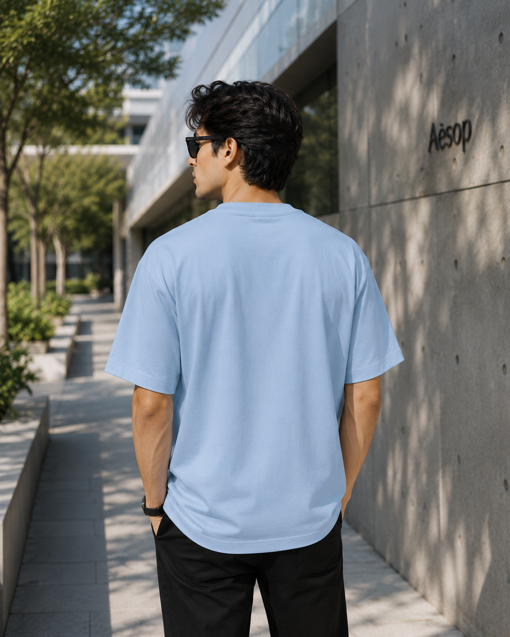 Back view of men wearing KØMN sky blue oversized crewneck t-shirt in relaxed fit, 200 GSM cotton tee