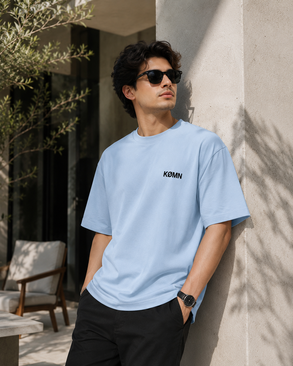 Men wearing KØMN sky blue oversized crewneck t-shirt with black logo front view, relaxed fit cotton tee