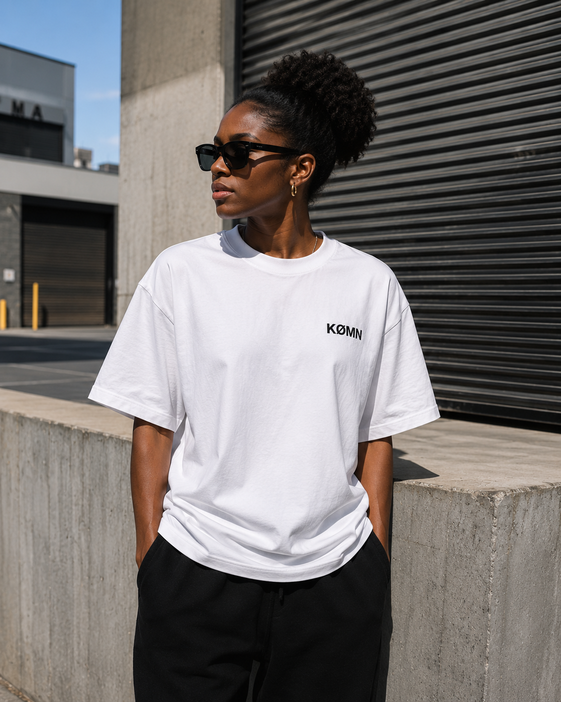 Woman wearing KØMN white oversized crewneck t-shirt with black logo, heavyweight cotton relaxed fit tee